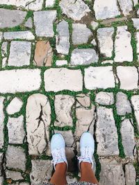 Low section of woman standing on footpath