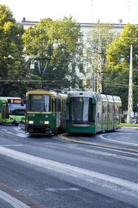 Cars on road against trees in city