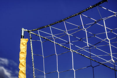 Low angle view of fence against blue sky