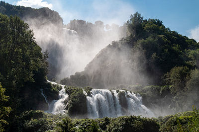 Scenic view of waterfall against sky