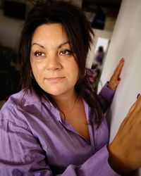 Close-up of woman leaning on wall at home