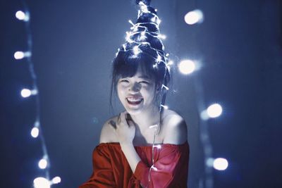 Portrait of woman against illuminated light