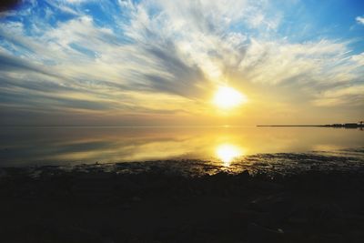 Scenic view of sea against dramatic sky during sunset