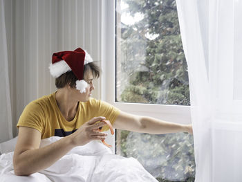 Man in santa hat is waking up after christmas. headache . alcohol withdrawal. worst hangover. 