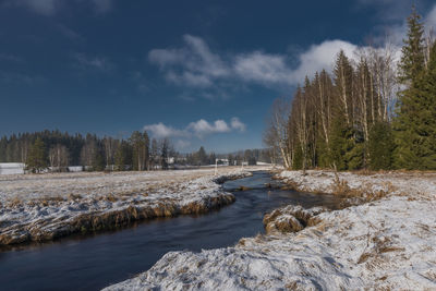 Scenic view of river against sky during winter