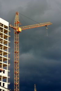 Low angle view of crane against sky