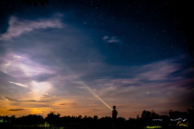 Silhouette trees against sky at night