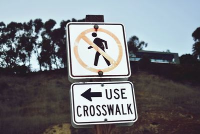 Close-up of road sign against sky