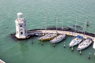 Pier with lighthouse and bots in venice lagune
