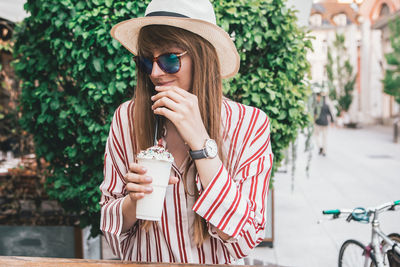 Young woman drinking water from coffee