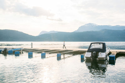 Side view of man walking on jetty over lake