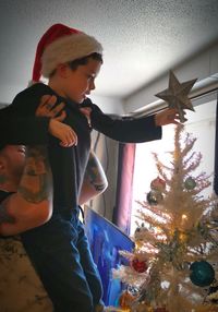Boy in christmas tree at home