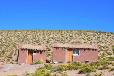 House on desert against clear blue sky