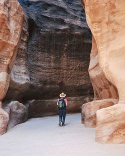 Rear view of man standing in cave