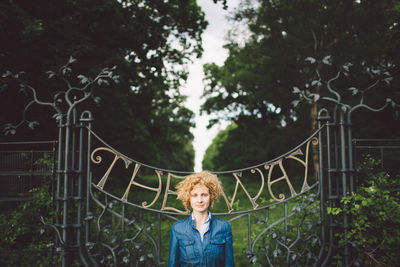 Portrait of woman standing against trees