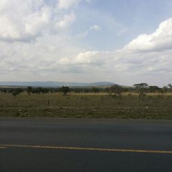 Country road against cloudy sky