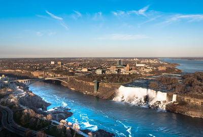 High angle view of sea by city against sky