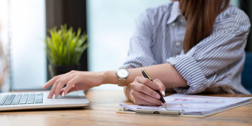 Midsection of woman working on table