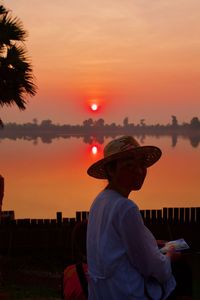 Man standing against orange sky during sunset