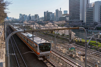 Railroad tracks in city against sky