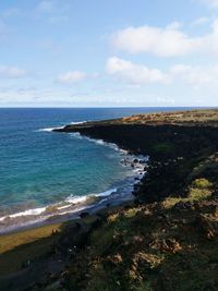 View of calm blue sea against cloudy sky