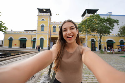 Smiling girl takes selfie in front of the public market of florianopolis, santa catarina, brazil