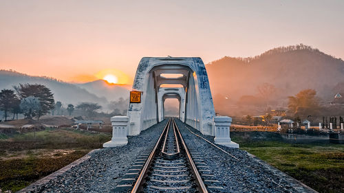 Railroad tracks against sky during sunset