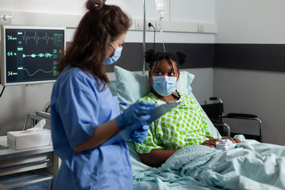 Nurse wearing mask examining patient