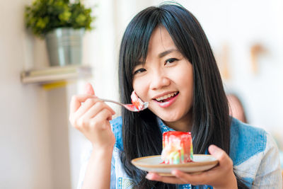 Portrait of a smiling young woman eating food