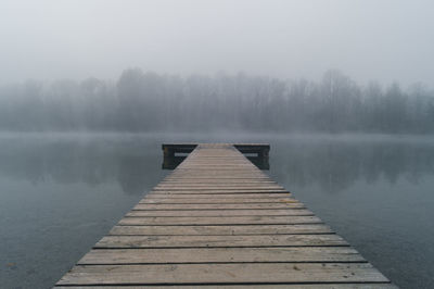 Pier over lake against sky