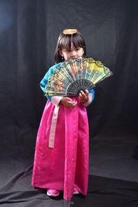 Rear view of girl holding multi colored umbrella