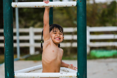 Portrait of shirtless boy standing outdoors