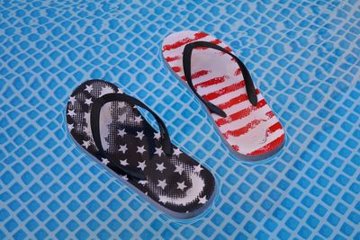 High angle view of slippers floating on swimming pool