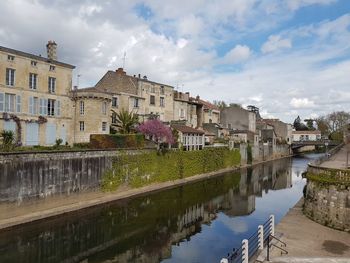 Canal amidst buildings against sky