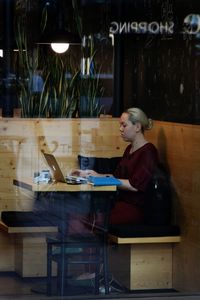 Woman looking at camera while sitting on table