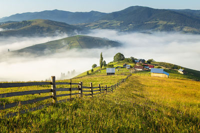 Scenic view of field against mountains during sunrise