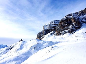 Low angle view of snowcapped dolomites against sky