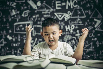 Portrait of boy with arms raised in background