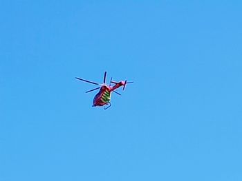 Low angle view of airplane against clear blue sky