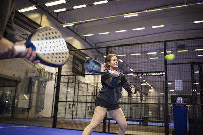 Woman playing padel at indoor court