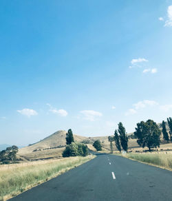 Road amidst trees against sky