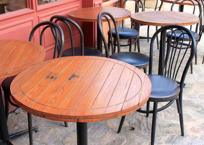 Wood tables and black chairs set up for lunch outside cafe