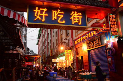 People on illuminated street market in city