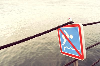 Close-up of warning sign on rope
