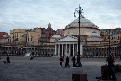 Tourists in front of building against sky