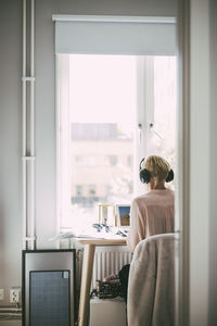 Rear view of man sitting on table at home