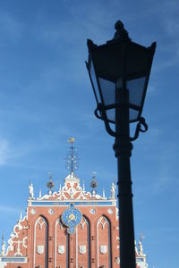 Low angle view of gas light and house of the blackheads at town square against sky