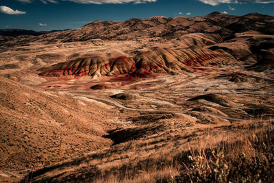 The painted hills in oregon. pretty unique and colorful mountain with red stripes on it.