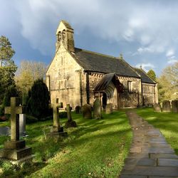 Graveyard outside st john the baptist church against cloudy sky