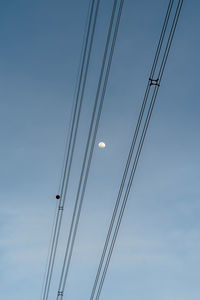 Low angle view of power lines against sky